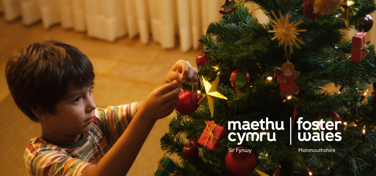 young boy putting decoration on christmas tree