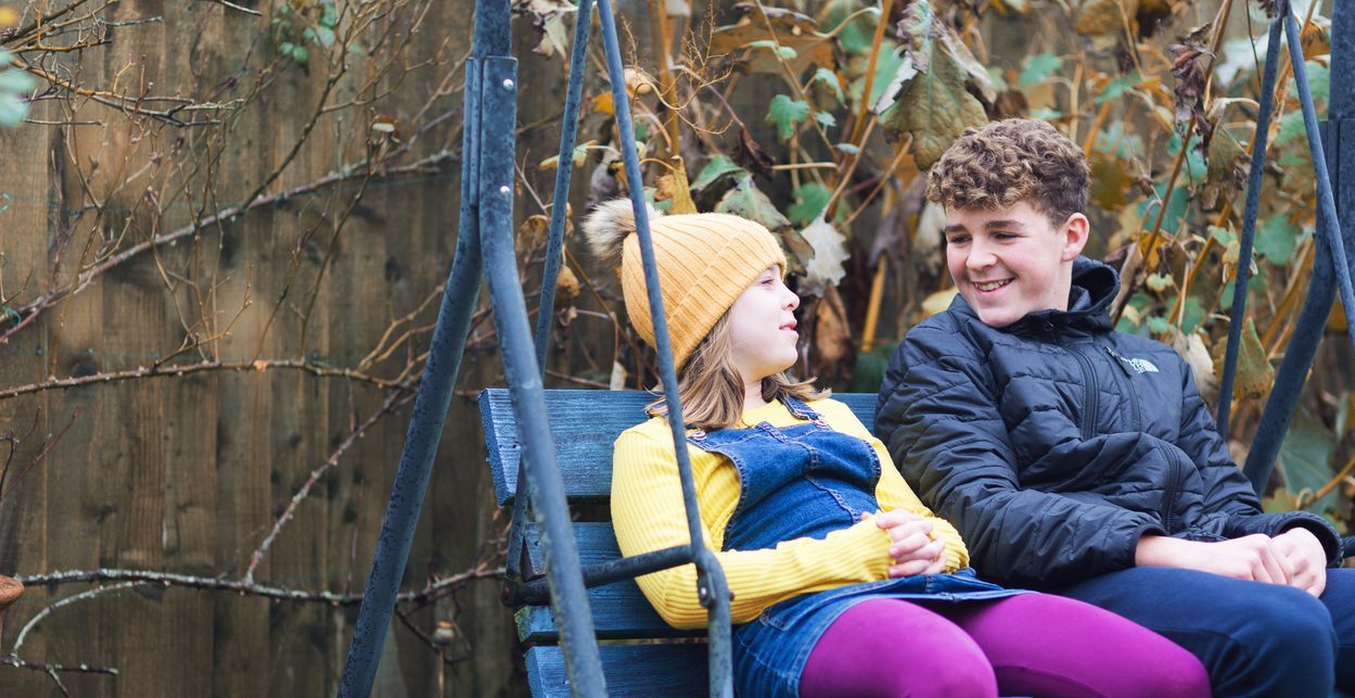 Boy and girl on a garden swing Fostering in Monmouthshire