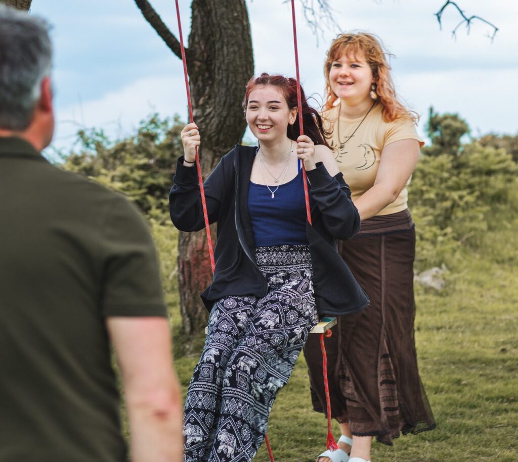 girl laughing on outdoor tree swing