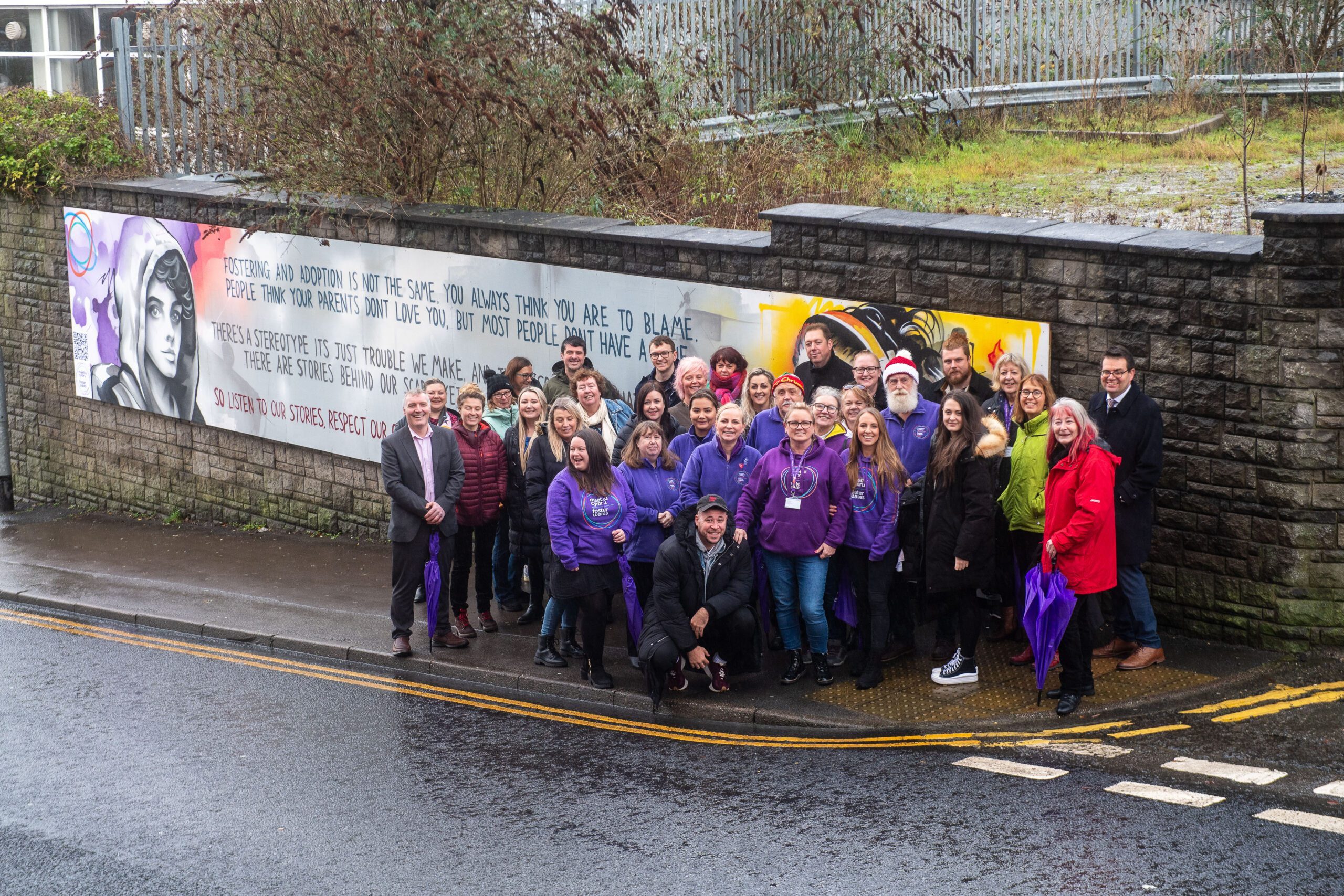 Group standing in front of mural